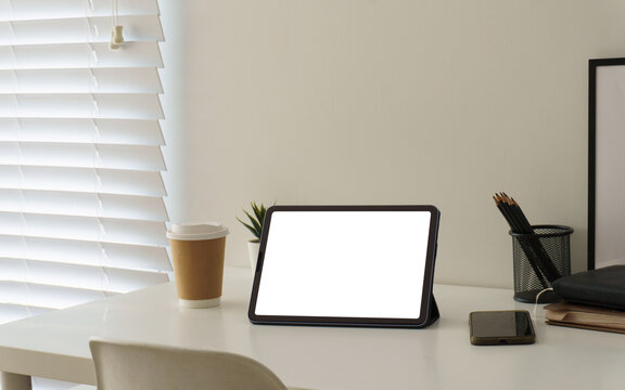 Blank tablet screen displayed on a clean modern workspace desk.