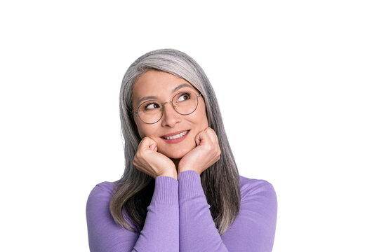 Photo of dreamy pretty retired lady hands fists cheekbones toothy smile look up empty space wear spectacles eyewear white shirt violet cardigan isolated grey color background