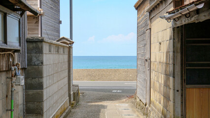 海岸線沿いの集落にある細い路地の先に広がる青い海 © ToYoPHoTo