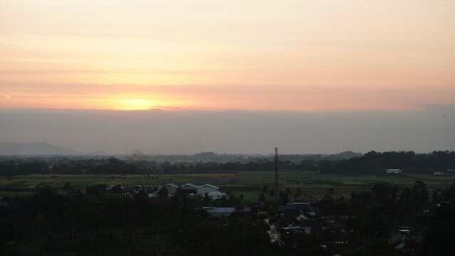 Elevated wide view captures colorful sunset sky above Tawangrejeni village, Turen, Malang, Indonesia.