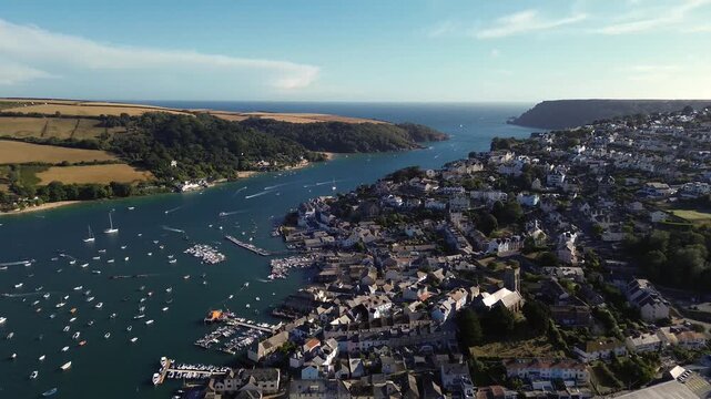 Salcombe harbour filled with boats on a sunny summer day - cinematic drone view