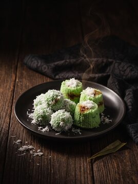 Kue Klepon. Kue Klepon kue putu tradisional. Indonesian Traditional Klepon and Putu Cakes. Kue Klepon Dark Moody Plate. Traditional Indonesian Green Klepon and Putu Rice Cakes Sweets with Coconut