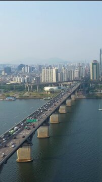 Aerial view from a drone. Vertical video of traffic on a bridge over the Han River in Seoul, South Korea.