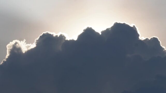 Dramatic dark clouds illuminated by sunlight in stormy sky