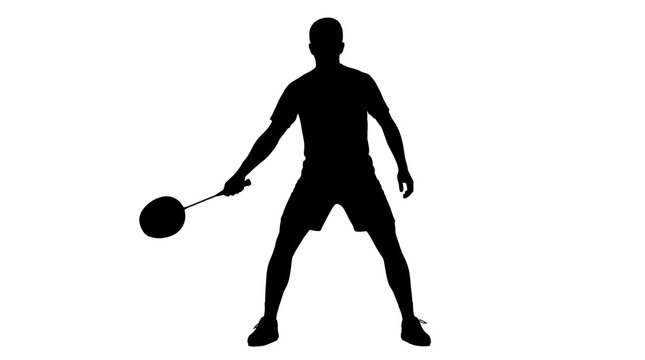 Man playing badminton silhouette with racket during a match with focused stance