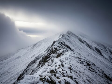 Snowy mountain peak under cloudy sky