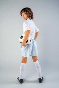 Smiling male youth soccer player in uniform looking back over his shoulder at the camera
