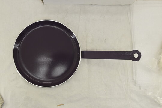 Black frying pan viewed from above against a clean light background, emphasizing its circular shape and cooking surface.