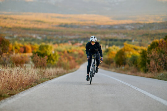 Road Cyclist Training On Scenic Autumn Highway At Sunrise Fitness Cycling Athlete Outdoor Endurance