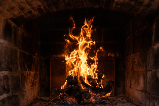 Roaring flames burning in old stone fireplace