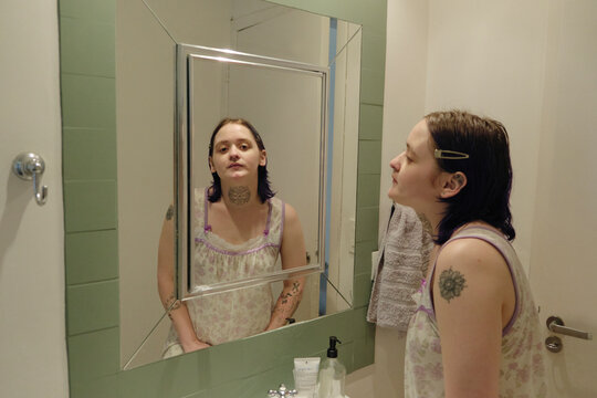 Portrait of a person in front of a mirror in the bathroom