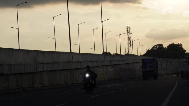 Sunrise highway traffic with truck and motorcycle rider