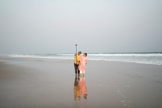 Middle aged Indian couple enjoying holiday and taking selfie 