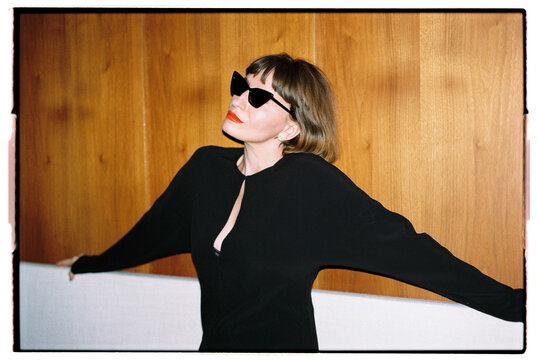 A fashion woman with a short haircut and black sunglasses at profile