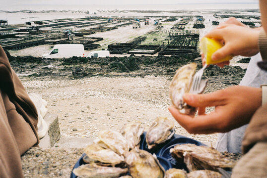 Squeezing lemon over fresh oysters