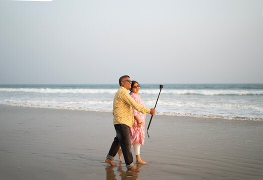 Middle aged Indian couple enjoying holiday and taking selfie 