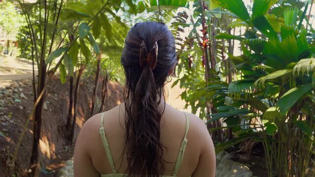 Adventurous individual walking through tropical green jungle
