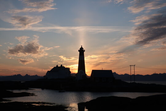 Light beam behind Lighthouse Silhouette during Sunset on Lofoten
