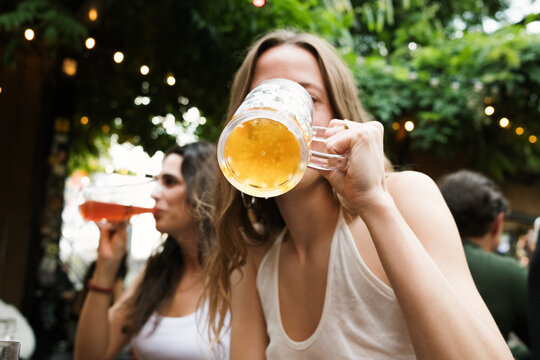 Friends enjoy drinks at a bar in a lively outdoor setting