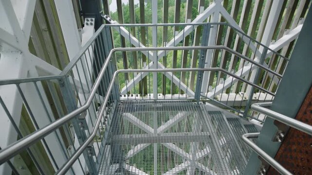 Walking down metal stairs in observation tower