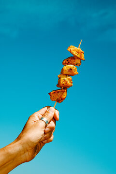 a man wearing a silver thumb ring holds a spanish pincho moruno