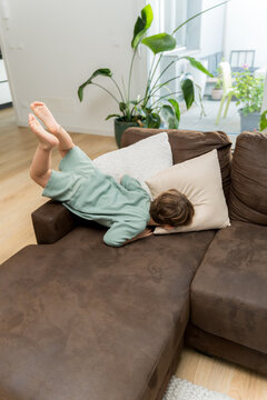 A toddler jumping on the sofa in the living room