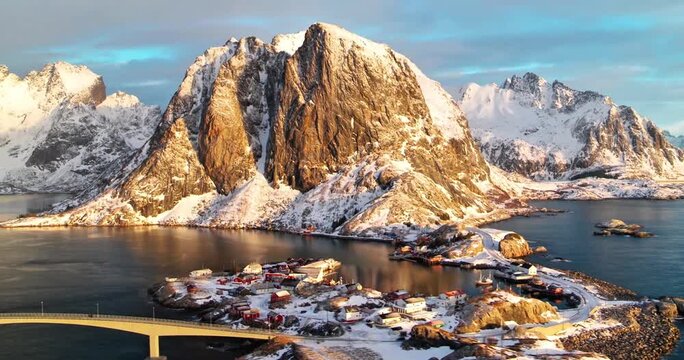 Aerial View of Hamn&oslash;y Fishing Village in Lofoten, Norway, During Winter Sunrise with Snow-Capped Mountains and Fjord