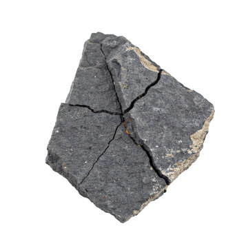 A single fragment of dark grey basalt rock with deep cracks and rough texture isolated on a transparent background