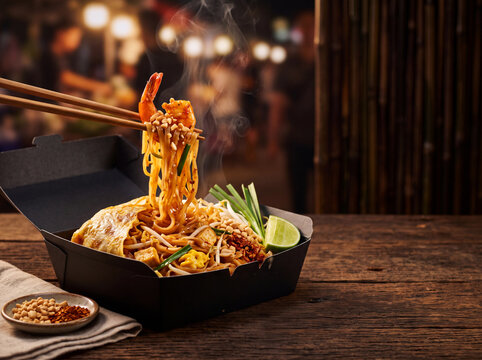 Chopsticks Lifting Pad Thai Noodles from Black Takeout Box