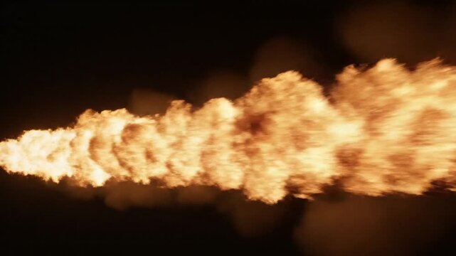 Intense rocket engine exhaust plume with bright fire and billowing dark smoke in aerospace test