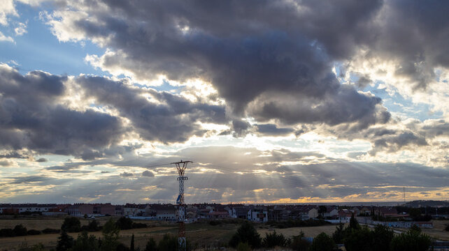 Cielo con nubes densas y rayos de luz sobre el horizonte urbano
