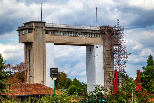 Lifting towers at gate in the Bosscherveld lock with connecting bridge under renovation work, scaffolding on huge pillars and white construction film, Maastricht, South Limburg, Netherlands