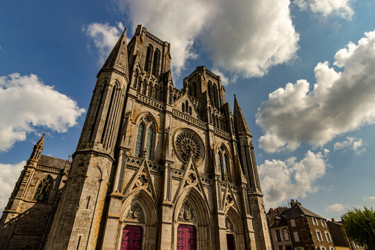 Dramatic low angle view of the Gothic revival facade of Eglise Notre Dame des Champs church in Avranches Normandy France under a stormy sky