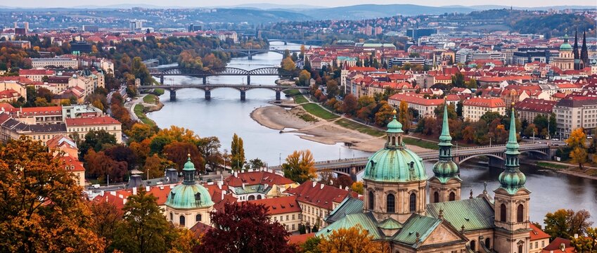 Panoramic aerial view of Prague cityscape with bridges over the Vltava river and historic buildings in autumn
