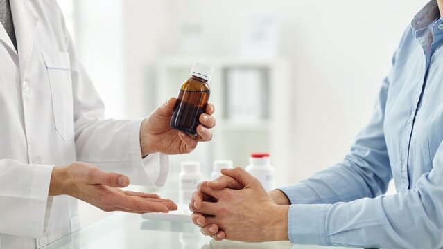 Doctor holding medicine bottle for patient consultation in medical office clinic setting