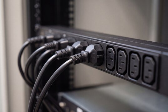 PDU power strip plugged in server rack data center equipment closeup