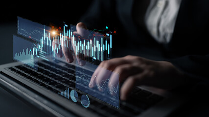 A business professional uses a laptop to analyze financial data, visualized through modern digital charts and graphs in a sleek office setting, representing innovation in finance. Scalp