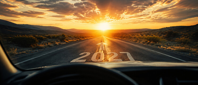 Driver perspective on an open road marked 2027 leading toward a dramatic sunrise, symbolizing a new year, future vision, progress, ambition, opportunity and success