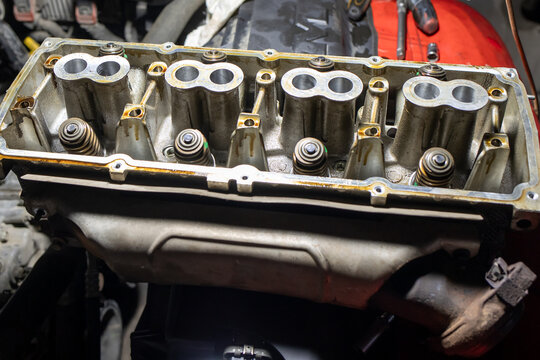 Close-up of a disassembled engine cylinder head showcasing valves, springs, and camshafts, ideal for automotive repair, mechanical engineering, and engine rebuild stock imagery.