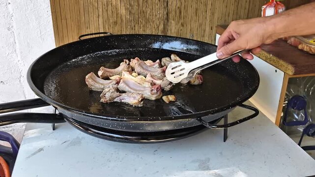 Beef ribs sizzling in frying pan during homemade high protein meal preparation