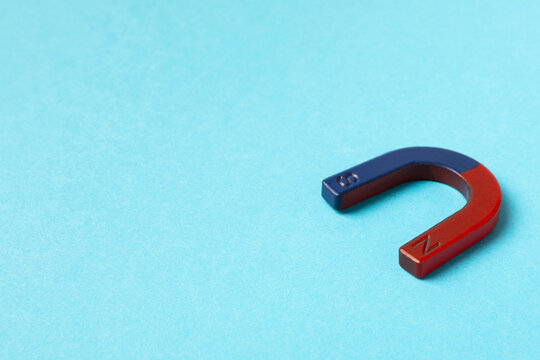 Magnet on a bright colored background. Magnetic attraction and force concept, symbol of pull, attraction, influence, connection and business strategy. Space for text. Copy space.