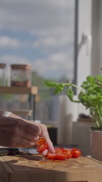 Hand removes pulp from cut tomato with small spoon on cutting board. Concept of cooking, fresh ingredients and recipe prep