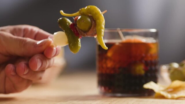 Gilda pintxo, traditional Spanish tapas with hot green pepper, anchovy, olives and pickled vegetables, served with vermouth