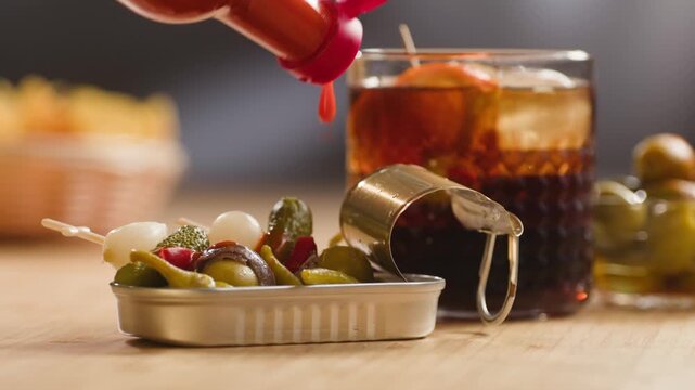 Gilda pintxo, traditional Spanish tapas with hot green pepper, anchovy, olives and pickled vegetables, served with vermouth