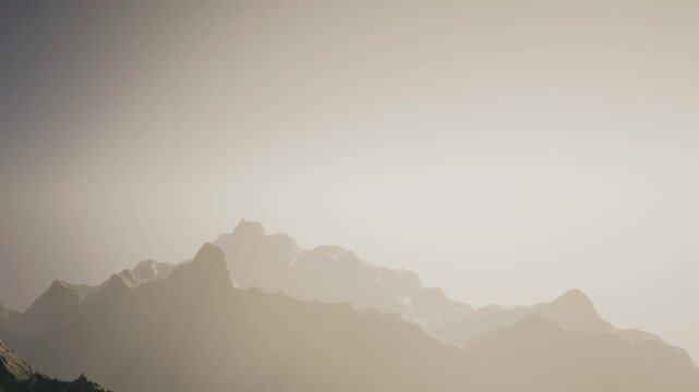 Mountains can be seen far away under soft light during the early hours of the day. The scene shows a hazy view with muted colors and outlines of the peaks.