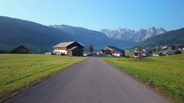 First-person drive POV through Gosau, Austria on a misty morning, alpine village & mountain landscape.