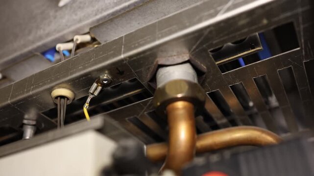 Heating season begins as a home boiler warms the room while exposed internal components show heating equipment operating to maintain indoor comfort during coldest weather