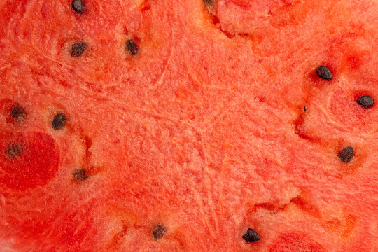 Textured background: juicy red watermelon flesh with seeds