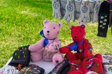 Fototapeta premium Handmade Embroidered Teddy Bears and Knitted Mittens at Outdoor Market