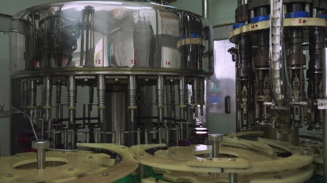 Automated machinery in the food and drink industry. Warming up machinery before production. Machine used in beverage production lines. Empty modern conveyor belt in bottling manufacturing industrial. 